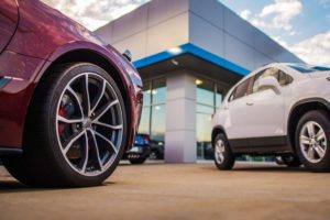 ars parked outside a modern dealership showcasing inventory under a blue sky