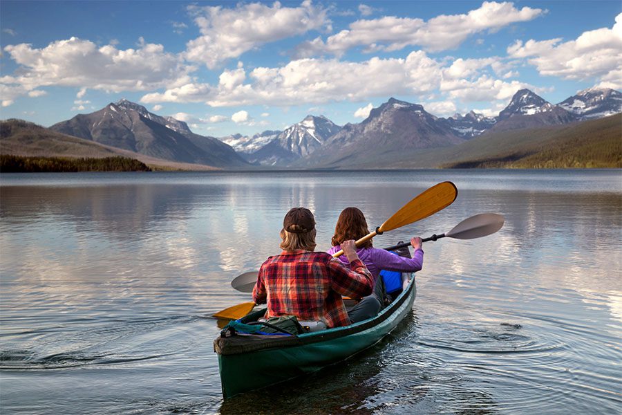 Client Center - Portrait of a Couple in a Canoe on a Scenic River with Views of Mountains in the Background