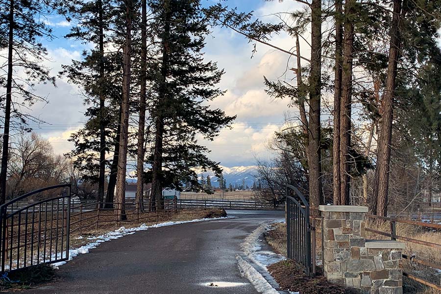 Amazing Feedback - View of an Open Front Gate to a Horse Ranch in Montana During the Winter with Views of the Mountains in the Background